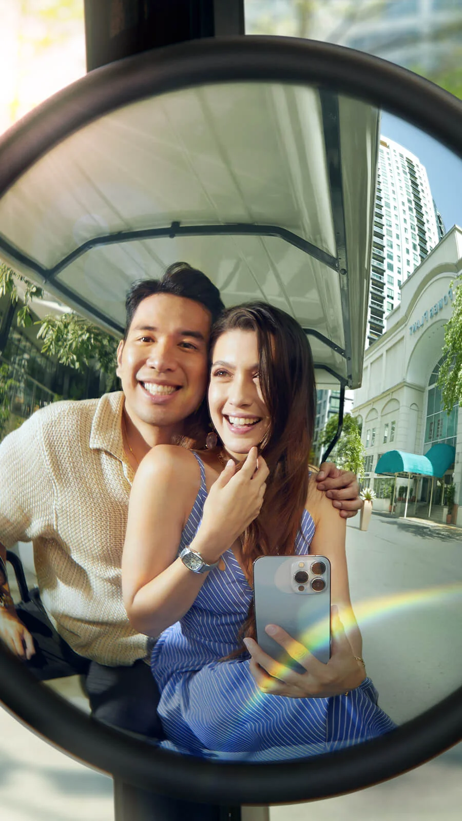 A joyful couple, captured in a sunny reflection, smiles brightly.